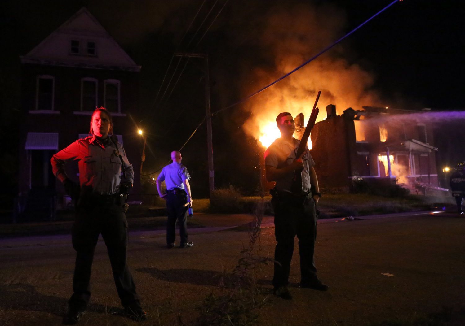 Officers guard firefighters at burning house on Bayard